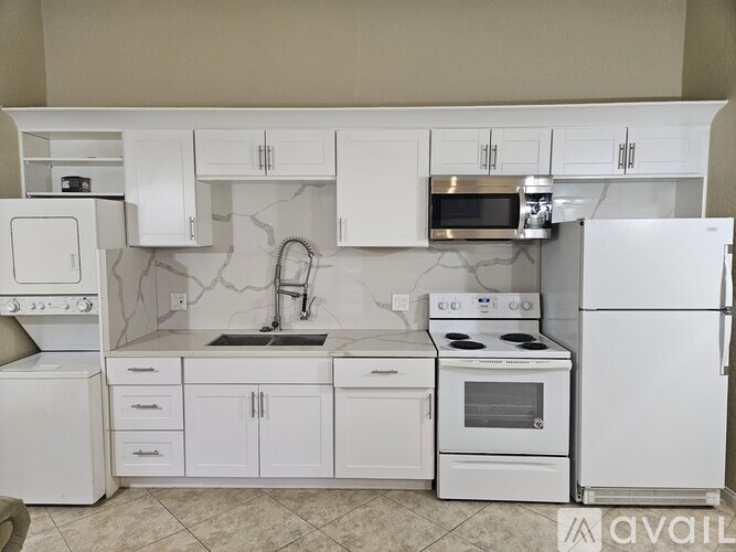 A bathroom with a granite counter top and a walk in shower.