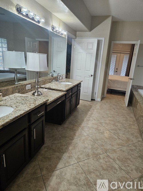 A bathroom with a walk-in shower and double sinks.