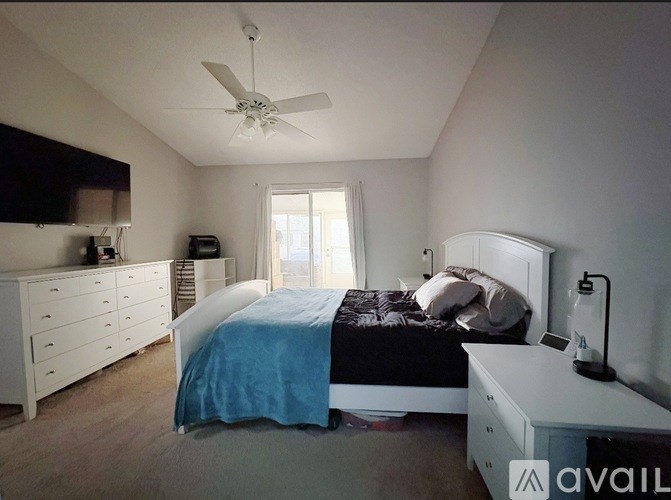 A bedroom with a bed, dresser, and ceiling fan.