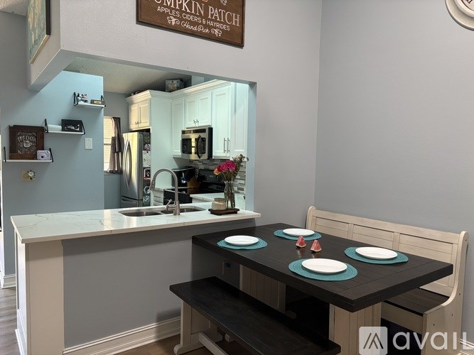 A kitchen with a table set for two and a sign that says "Pumpkin Patch".