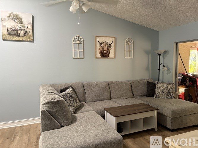 A living room with a grey sofa and a wooden coffee table.