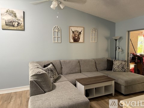 A living room with a grey sofa and a wooden coffee table.