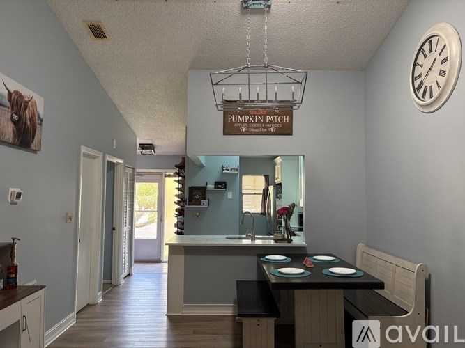 A kitchen with a table and chairs and a clock on the wall.