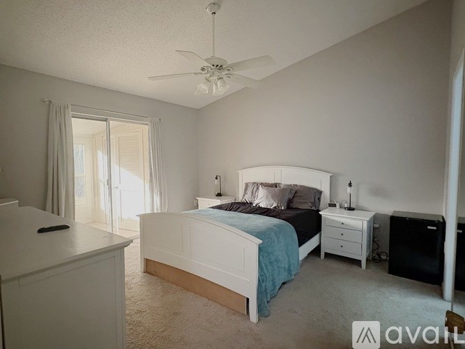 A bedroom with a bed, dresser, and ceiling fan.