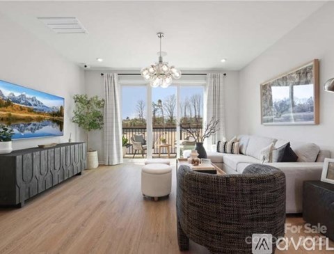 A living room with a large window and a painting of a mountain landscape on the wall.