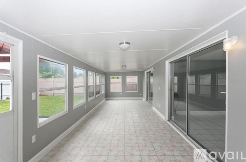 A long hallway with tiled floors and glass doors.