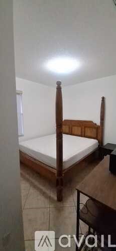 A bedroom with a bed, nightstand, and chair.