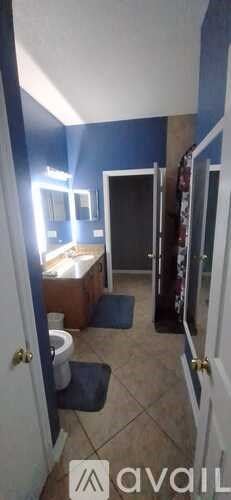 A bathroom with blue walls and a white toilet.