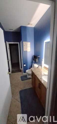 A bathroom with blue walls and a toilet.