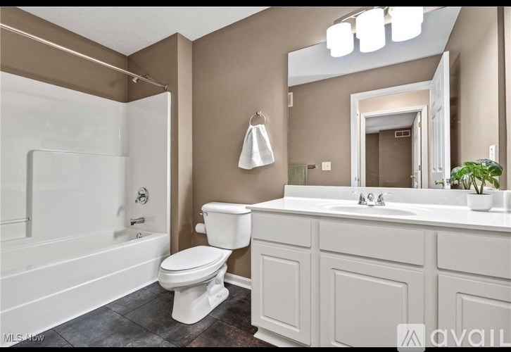 A white toilet is in a bathroom with brown walls.