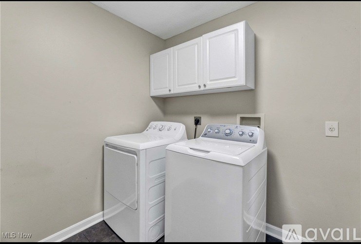 Two white front load washing machines in a laundry room.