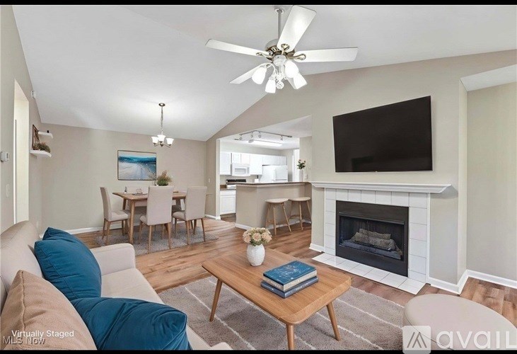 A living room with a fireplace and a television mounted on the wall.