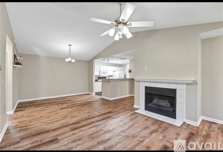 A living room with a fireplace and wood flooring.