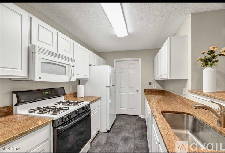 A kitchen with white cabinets and a black stove top.