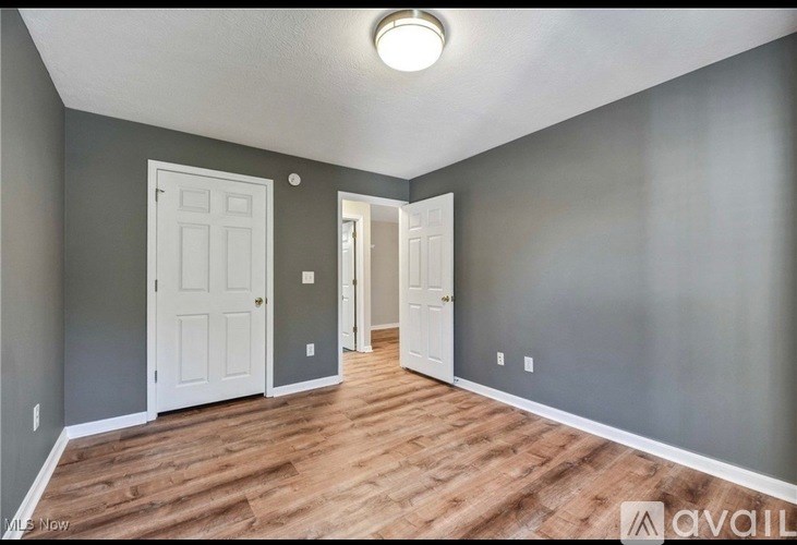 A room with wooden floors and two white doors.