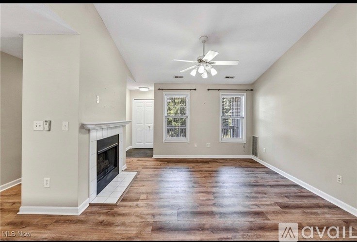 A spacious living room with a fireplace and hardwood floors.