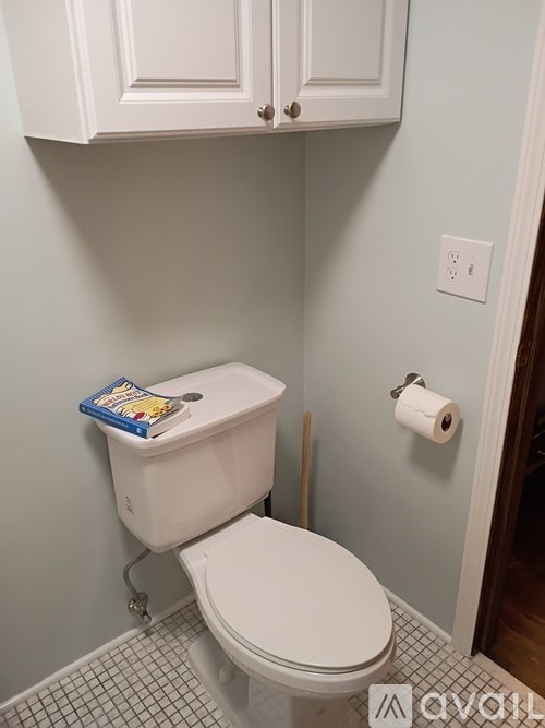 A white toilet with a book on top of it.