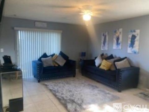 A living room with two couches and a rug.