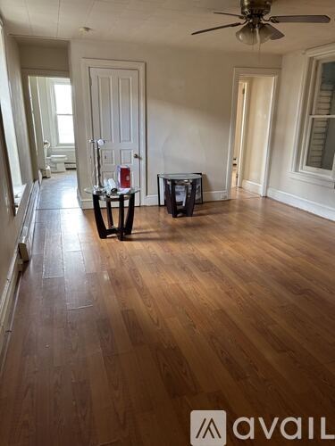 A room with wooden floors and a ceiling fan.