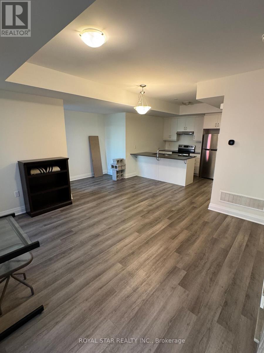 A spacious living room with wood flooring and a fireplace.