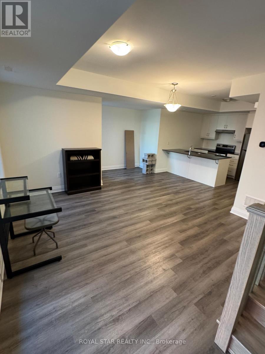 A spacious room with wooden flooring and a glass table.