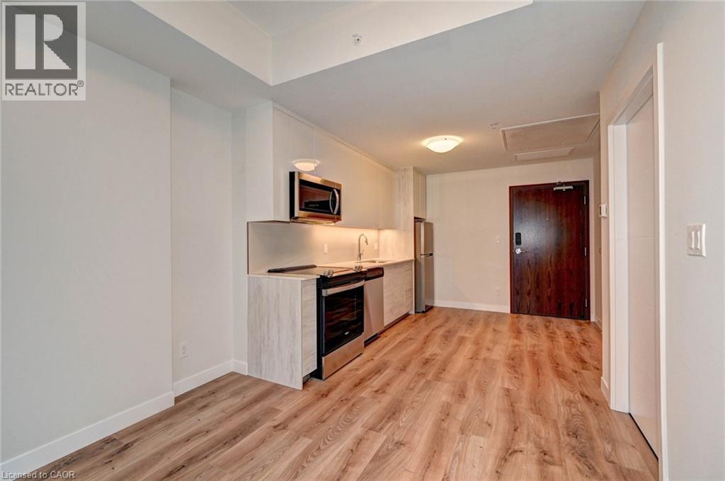 A spacious room with wooden flooring and a television mounted on the wall.