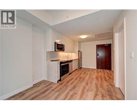 A spacious room with wooden flooring and a television mounted on the wall.