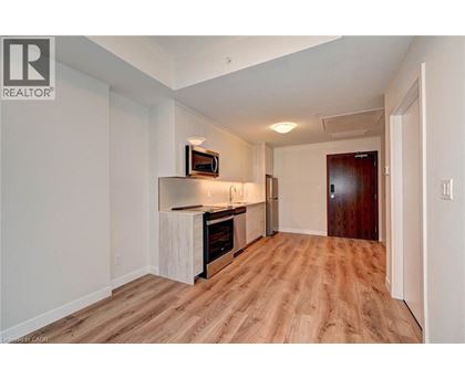 A spacious room with wooden flooring and a television mounted on the wall.