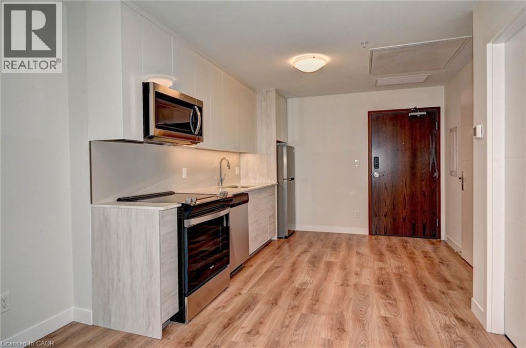 A kitchen with a white counter top and a microwave on it.