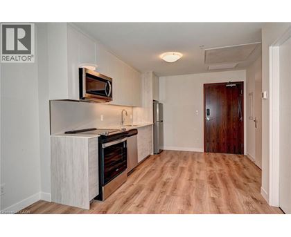 A kitchen with a white counter top and a microwave on it.