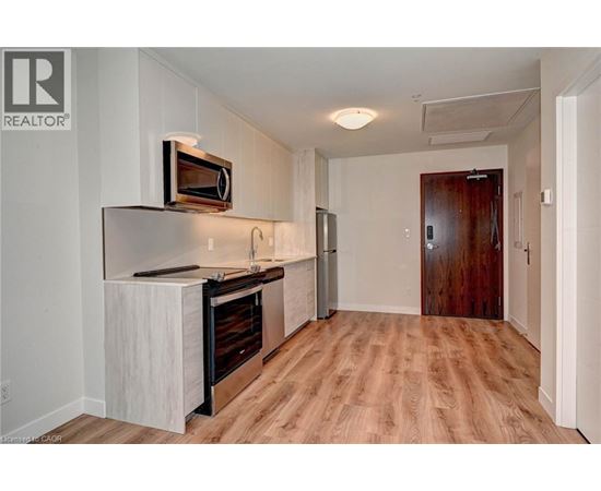 A kitchen with a white counter top and a microwave on it.