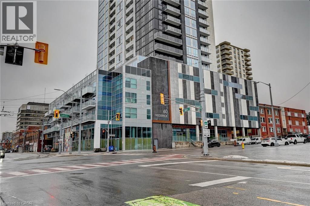 A tall building with a glass facade is in the center of a city street.