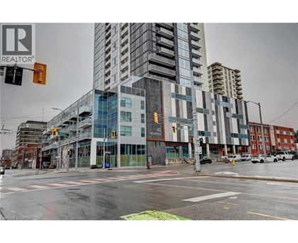 A tall building with a glass facade is in the center of a city street.