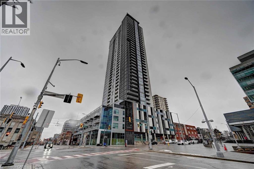 A tall building stands in the middle of a city intersection.