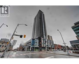 A tall building stands in the middle of a city intersection.