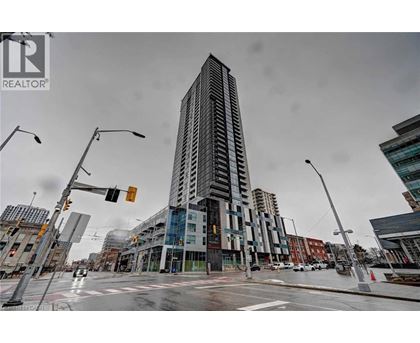 A tall building stands in the middle of a city intersection.