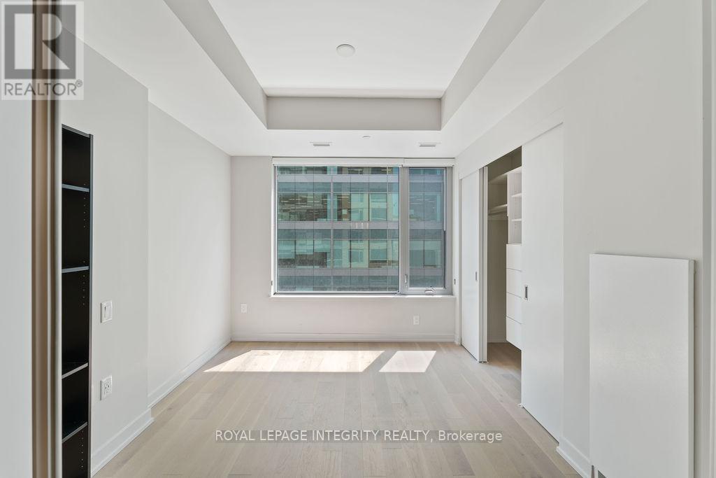 A spacious, empty room with a large window and a view of a cityscape.