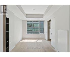 A spacious, empty room with a large window and a view of a cityscape.