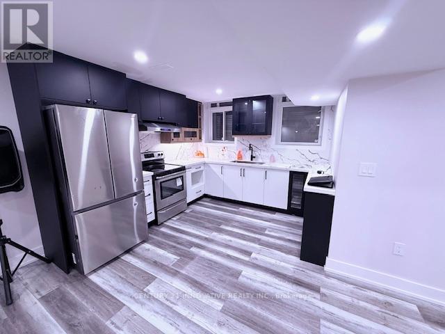 A modern kitchen with a refrigerator, oven, and cabinets.