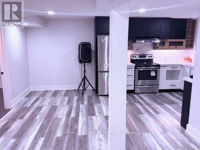 A kitchen with a refrigerator, oven, and microwave.