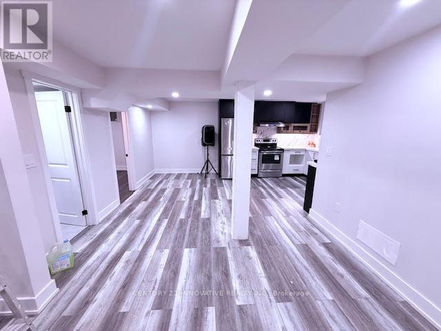 A room with a wooden floor and a speaker on a stand.