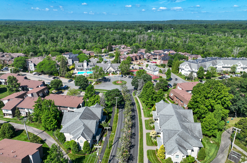 A bird's eye view of a residential area with houses and a swimming pool.