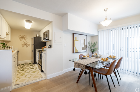 A modern kitchen with a dining table set for two.