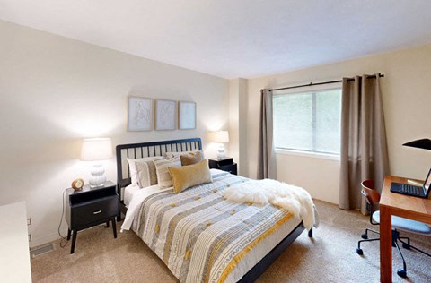 a bedroom with a bed and a desk and a window