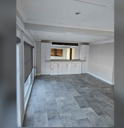A kitchen with white cabinets and a window.