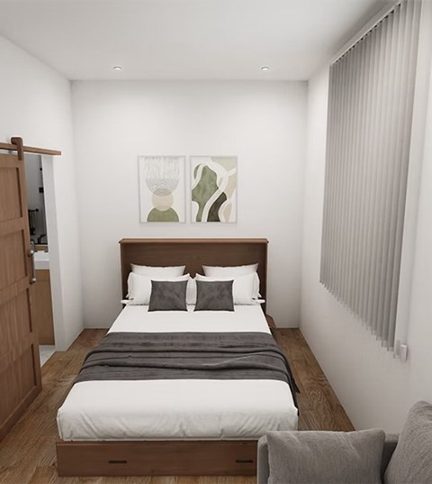 A bedroom with a bed, two chairs, and a painting on the wall.