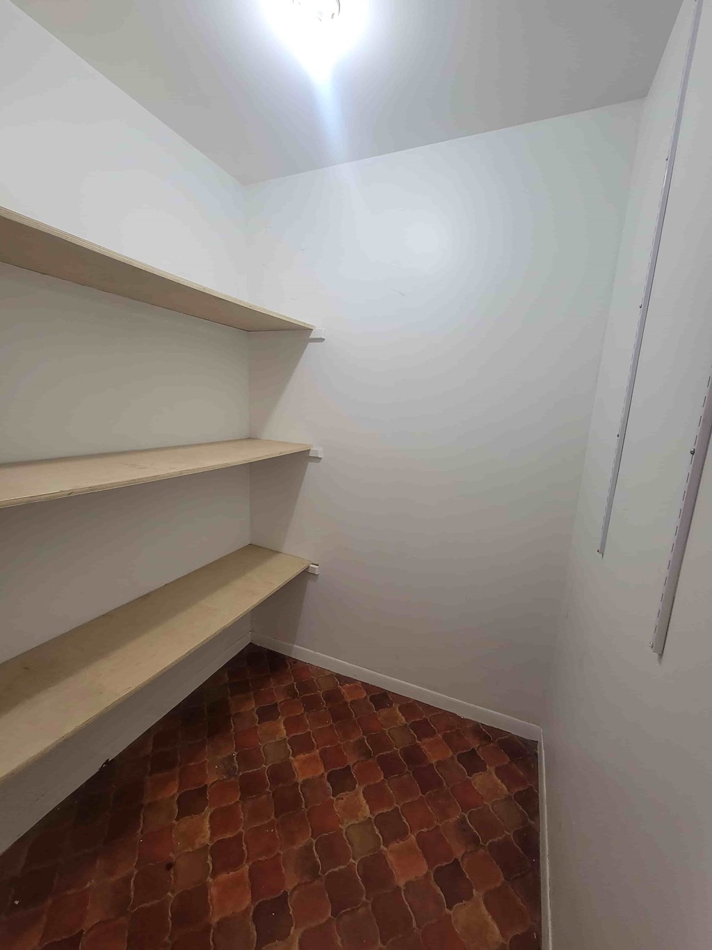 A room with a checkered floor and a white wall.