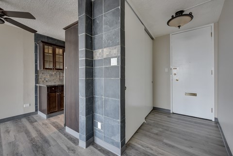 A room with a white door and a ceiling fan.