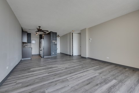 A room with a ceiling fan and wooden flooring.