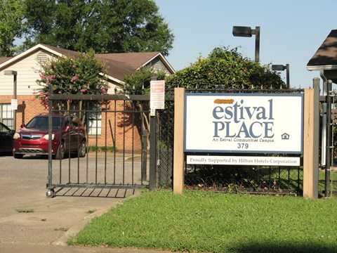 A sign for the Estival Place Assisted Living Campus is displayed in front of a gated entrance.